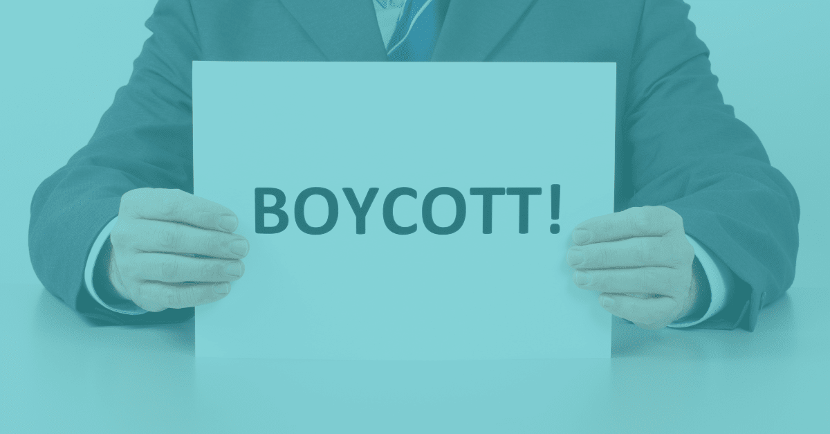 Man holding paper up with Boycott written on it